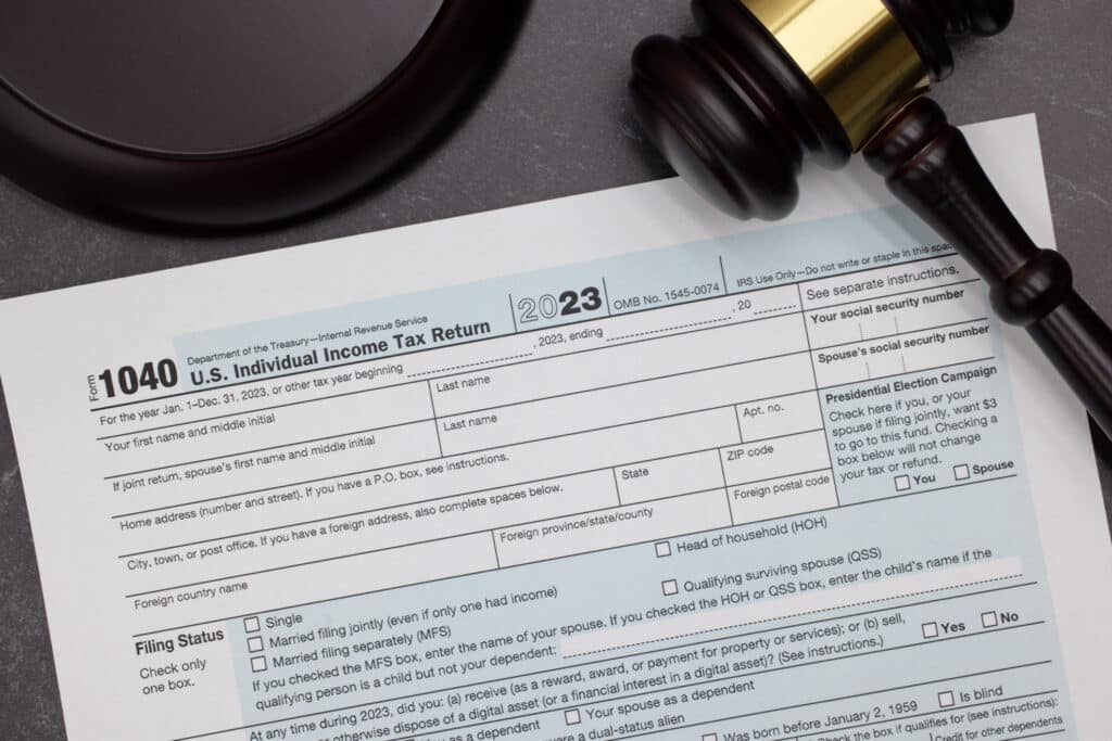 Photo of an income tax form on a table with a mallet