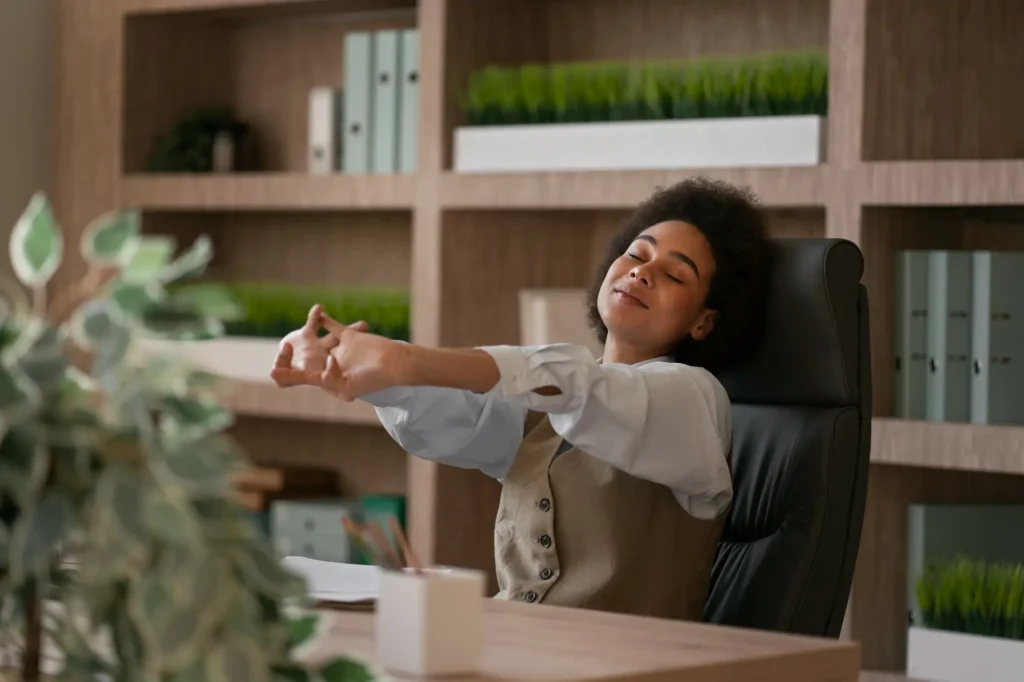 Woman stretching her arms at her desk